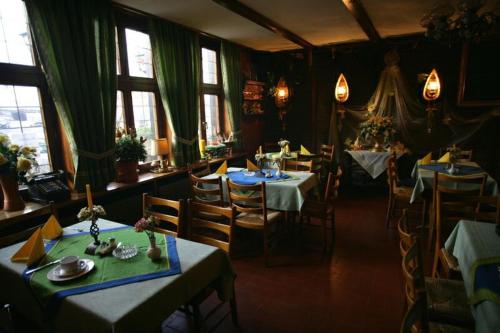 ein Esszimmer mit Tischen, Stühlen und Fenstern in der Unterkunft Haus Wessel in Köln