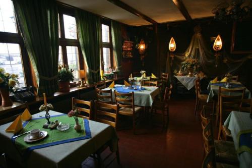 a dining room with tables and chairs and windows at Haus Wessel in Cologne