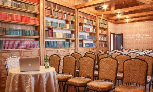 a row of chairs in a library with a table with a laptop at Hotel Kilikiya in Uzhhorod