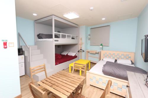 a bedroom with a bed and a table and chairs at Daegu Midtown Hostel in Daegu
