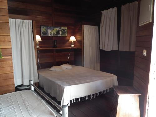 a bedroom with a bed in a wooden room at Le Cardinal des Grands Bleus in Saint-Leu