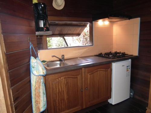 a small kitchen with a sink and a stove at Le Cardinal des Grands Bleus in Saint-Leu