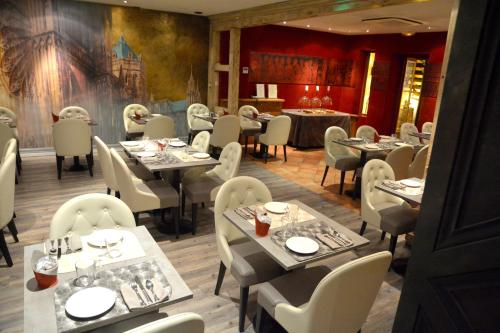 un restaurant avec des tables et des chaises dans une salle dans l'établissement Hotel Cathédrale, à Strasbourg