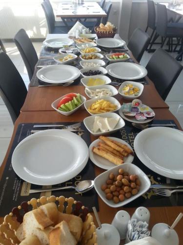 un lungo tavolo con piatti di cibo sopra di Grand Dost Hotel a Osmancık