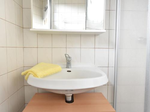 a bathroom with a white sink and a yellow towel at Gorgeous home with swimming pool and Jacuzzi Sea view ! in Boltenhagen