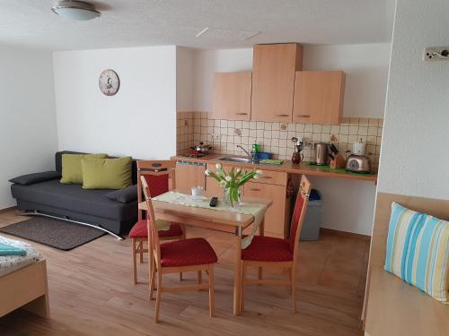 a kitchen and a living room with a table and chairs at Landsauna - Pension in Zittau