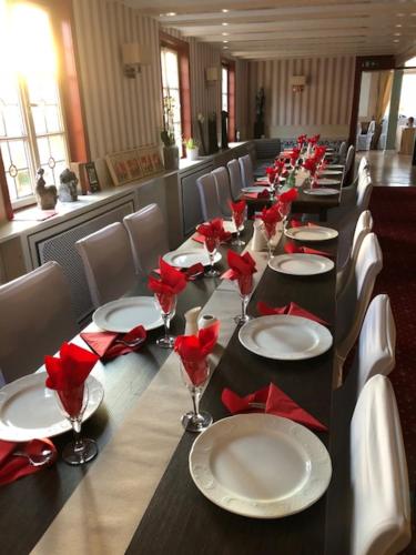 a long table with red napkins and plates on it at Hotel zur goldenen Sonne in Usingen