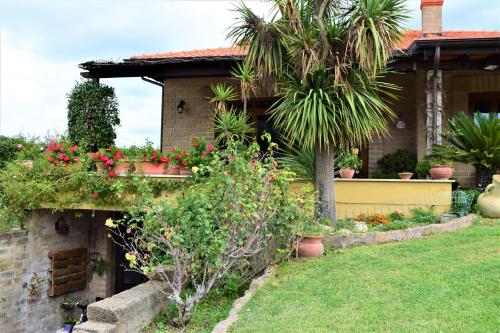 a house with a bunch of flowers in a yard at Il Casale Del Sogno in Ardea