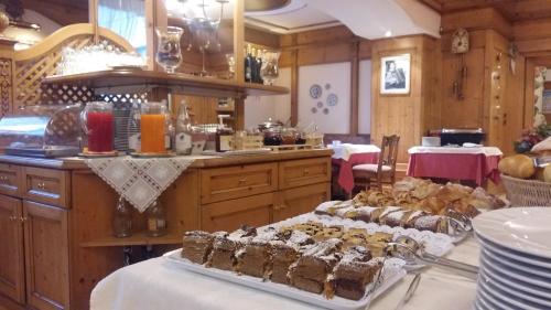 a kitchen with a bunch of desserts on a table at Hotel Alpina in Pinzolo