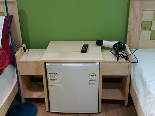 a desk with a remote control on top of a refrigerator at Daegu Midtown Hostel in Daegu