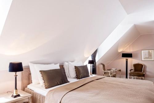 a bedroom with a large bed with white pillows at Kokkedal Slot Copenhagen in Hørsholm