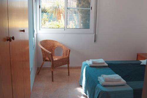1 dormitorio con 1 cama, 1 silla y 1 ventana en Casa Marga, en Riumar