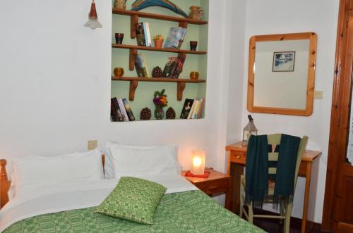 a bedroom with a bed and a mirror and a chair at To Balkoni tis Agorianis in Eptalofos