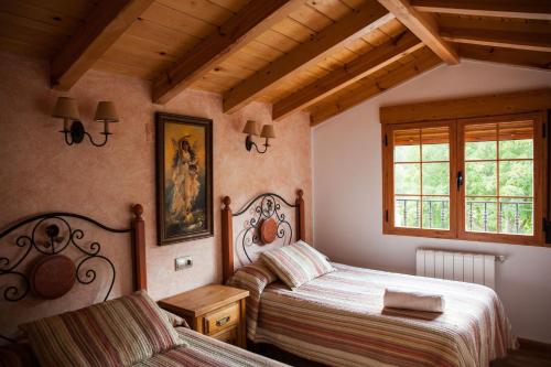 sypialnia z dwoma łóżkami i oknem w obiekcie Alojamiento Rural Casa Inocente w mieście La Toba
