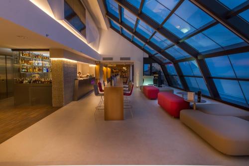a lobby of a building with red chairs and a bar at ESTIMAR Calpe Suitopia in Calpe