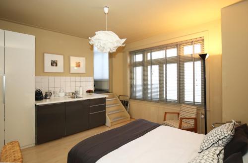sypialnia z łóżkiem oraz kuchnia ze zlewem w obiekcie Canal Studio Apartment w Amsterdamie