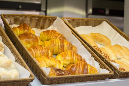 tre cestini pieni di croissant su un tavolo di Park Hotel Porto Gaia a Vila Nova de Gaia