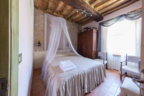 a bedroom with a bed with a mosquito net at Appartamenti turistici Vicolo S. Chiara in Sassoferrato