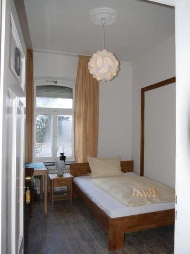 - une chambre avec un lit et un lustre dans l'établissement Alte Schmiede, à Ascheberg