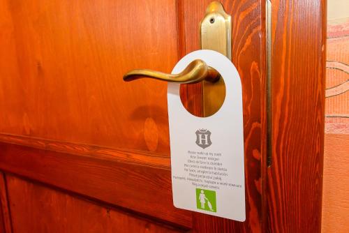 a door sign on a wooden door with a handle at Tinódi Fogadó in Sárvár