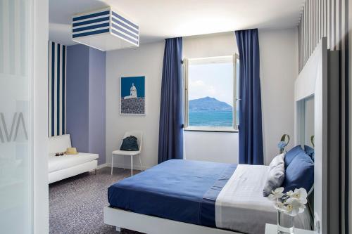 una camera con un letto blu e una finestra di Villa Aragonese Rooms a Monte di Procida