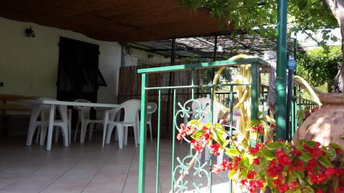 a porch with white chairs and a table and a fence at Come a casa in Deiva Marina