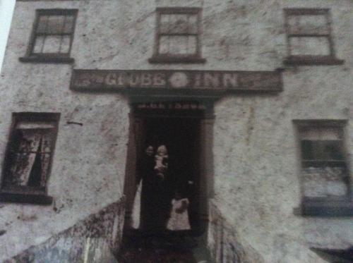 a woman standing in the window of a building at Globe Guesthouse in Burry Port