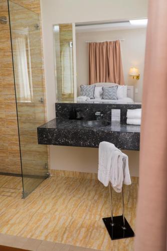 ein Badezimmer mit Waschbecken, Bett und Spiegel in der Unterkunft La Coupole Hotel in Quito