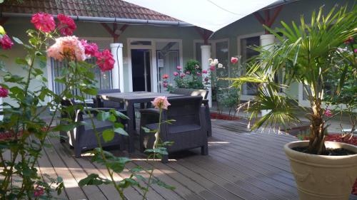 a patio with a table and chairs and flowers at Tinódi Fogadó in Sárvár