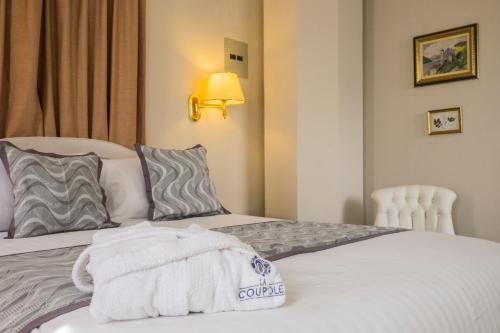 a hotel room with two beds with towels on them at La Coupole Hotel in Quito
