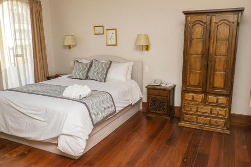 um quarto com uma cama e piso em madeira em La Coupole Hotel em Quito