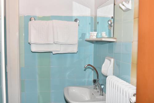 uma casa de banho com lavatório, espelho e toalhas em Hotel Hermes em Olympia