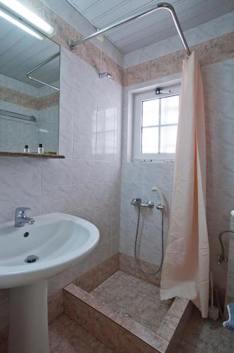 un baño con lavabo y ducha en Epidavria Hotel, en Tolo