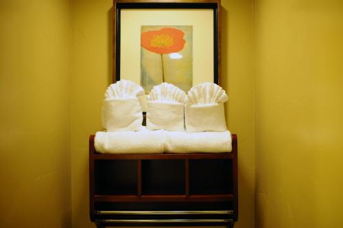 a towel rack with towels and a picture on a wall at Sunset Inn Pacific Grove in Pacific Grove