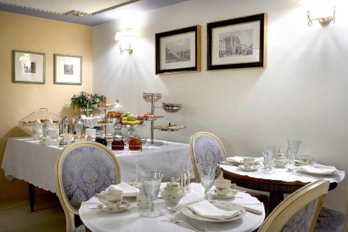 a dining room with a table and chairs with plates and glasses at Arhontiko Pepos in Nafpaktos