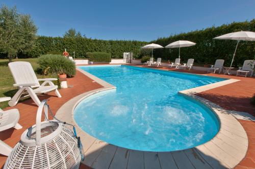 a large swimming pool with chairs and umbrellas at Casal di Peppe B&B in Orentano