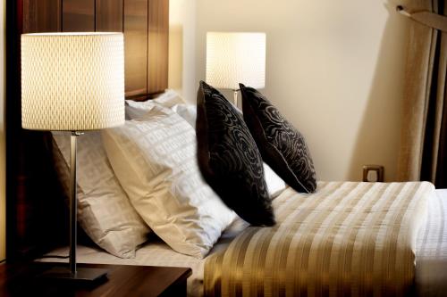 a bedroom with a bed with black and white pillows at أسوار للشقق المخدومة in Al Khobar