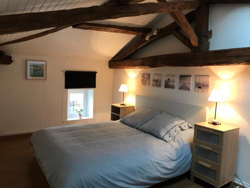 une chambre avec un grand lit et deux lampes dans l'établissement Les Vieilles Ombres, à Bagnizeau