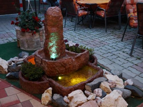 a fountain in a courtyard with a table and chairs at Tinódi Fogadó in Sárvár