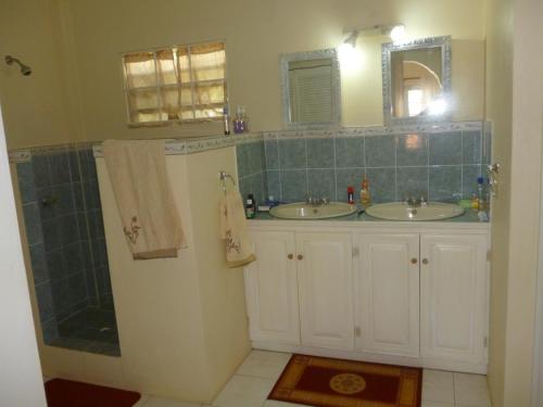 a bathroom with two sinks and a shower at Castles In Paradise Villa Resort in Vieux Fort