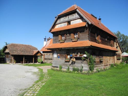 a large wooden house with a dog standing in front of it at Tradicije Cigoc in Čigoč