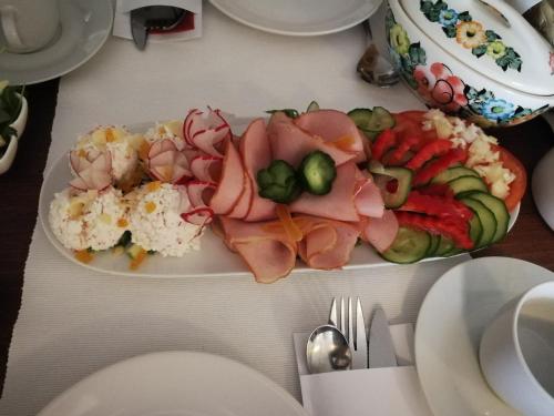 een bord met eten met vlees en groenten op een tafel bij Willa Solan in Ciechocinek