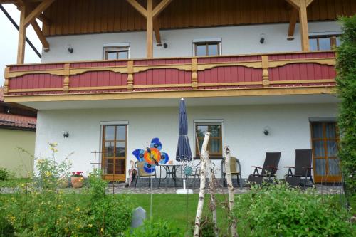 a house with a balcony with a table and chairs at Haus Ellerbeck in Bodenmais