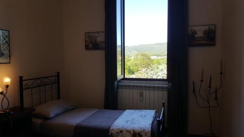ein Schlafzimmer mit einem Bett und einem großen Fenster in der Unterkunft Casa Pettini in Arezzo