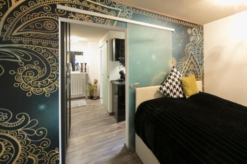 a bedroom with a black and gold patterned wall at Wohnung Stuttgart Mitte in Stuttgart