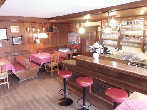 a restaurant with a bar with pink stools at Götschlhof in Schladming