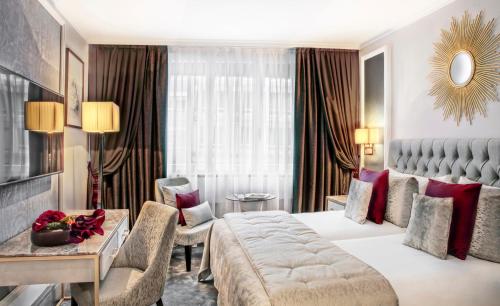 um quarto de hotel com uma cama grande e um sofá em Royal Manotel em Genebra