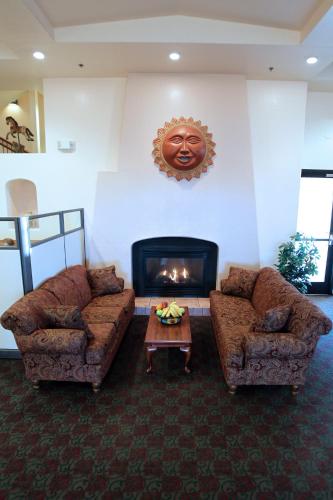 a living room with two couches and a fireplace at Gateway Studio Suites in Sierra Vista