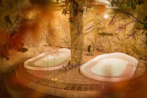 ein Bad mit einer Badewanne in einer Höhle in der Unterkunft Hotel Edelweiss in Prags