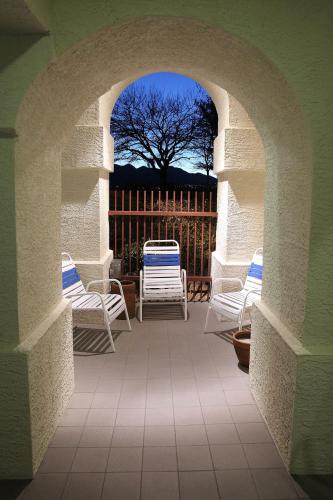 an archway with chairs and a tree in the background at Gateway Studio Suites in Sierra Vista